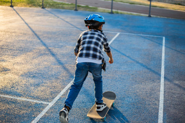 istock Young happy boy riding skateboard in the schoolyard 1183350472