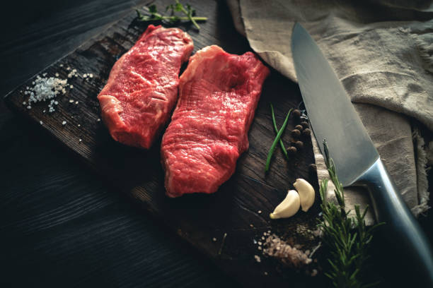 Two raw meat steak on a wooden Board on a table prepared for the grill. rustic style Two raw meat steak on a wooden Board on a table prepared for the grill. rustic style boneless chuck steak stock pictures, royalty-free photos & images