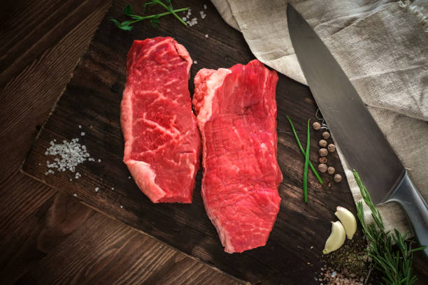 Two raw chuck steak on a wooden Board on a table prepared for the grill. Top view rustic style Two raw chuck steak on a wooden Board on a table prepared for the grill. Top view rustic style boneless chuck steak stock pictures, royalty-free photos & images