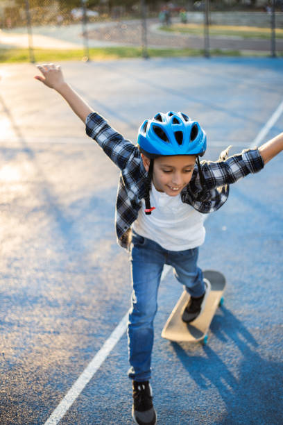 istock Young happy boy riding skateboard in the schoolyard 1183350726