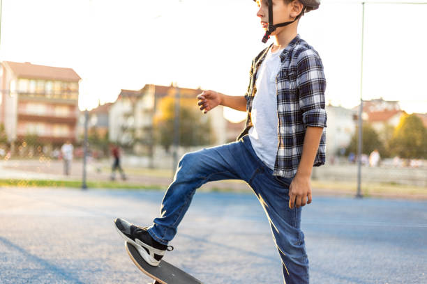 istock Young happy boy riding skateboard in the schoolyard 1183351168