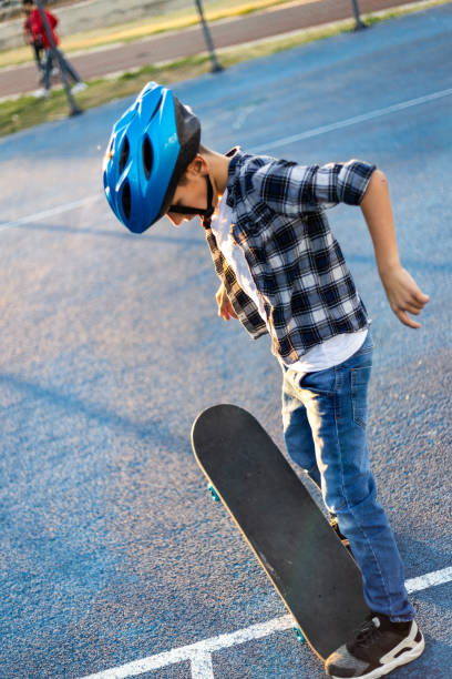 istock Young happy boy riding skateboard in the schoolyard 1183351174