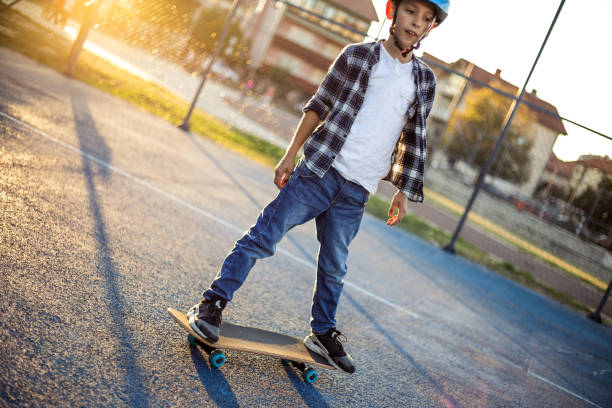 istock Young happy boy riding skateboard in the schoolyard 1183351392