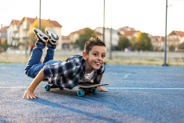 istock Young boy playing with skateboard in the schoolyard 1183352117