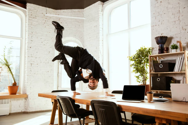 istock Businessman having fun dancing break dance in the office at work 1183352536