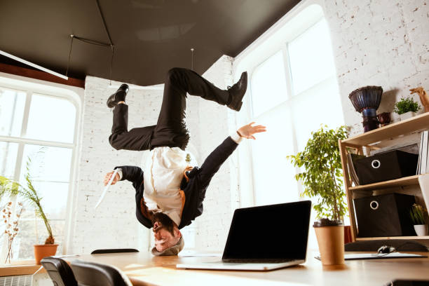 istock Businessman having fun dancing break dance in the office at work 1183352551