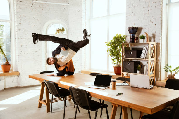 istock Businessman having fun dancing break dance in the office at work 1183352562