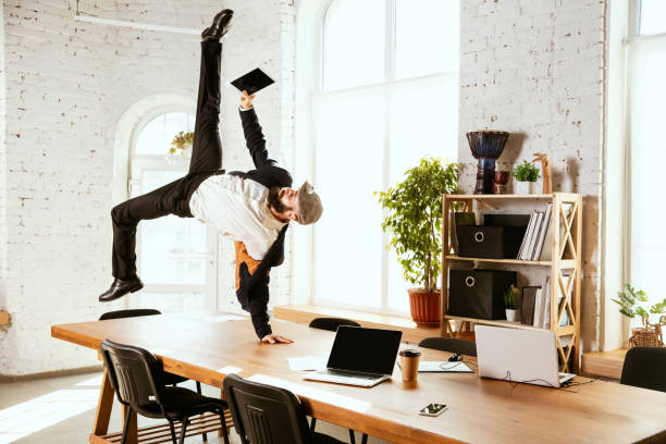 istock Businessman having fun dancing break dance in the office at work 1183352570