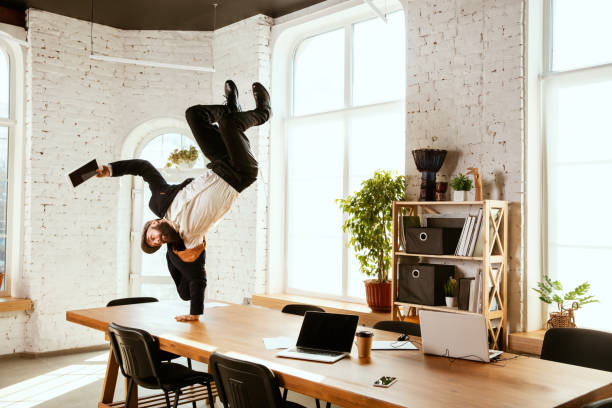 Businessman having fun dancing break dance in the office at work