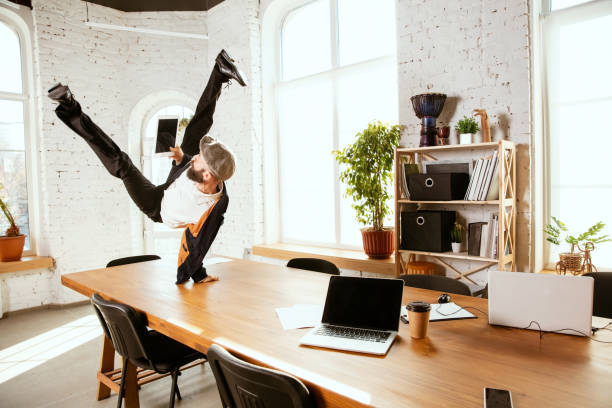 istock Businessman having fun dancing break dance in the office at work 1183352592