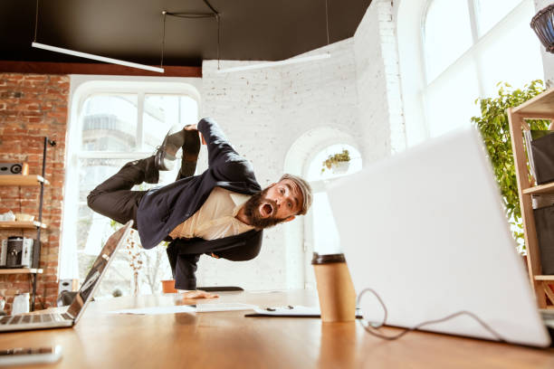 istock Businessman having fun dancing break dance in the office at work 1183352615