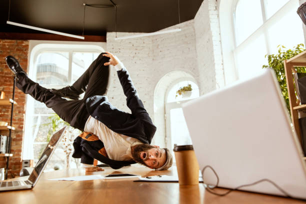 istock Businessman having fun dancing break dance in the office at work 1183352617