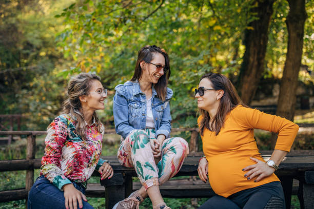 istock Three young women sitting in park 1183352639