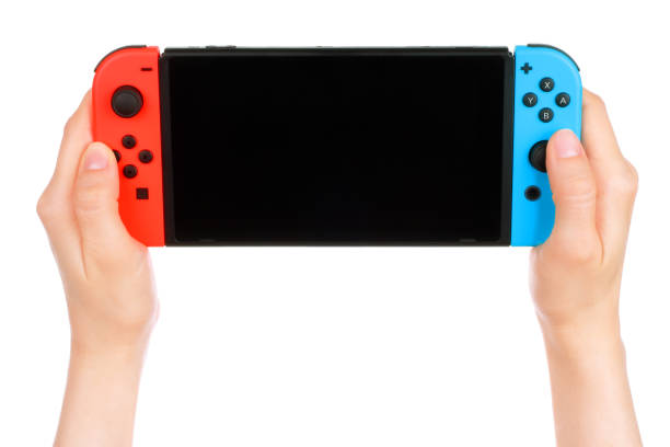Woman hands holding Nintendo Switch console Kiev, Ukraine - May 15, 2019: Woman hands holding Nintendo Switch console. Nintendo Switch is a hybrid video game console developed by Nintendo, and can be used as a stationary and portable device switch stock pictures, royalty-free photos & images
