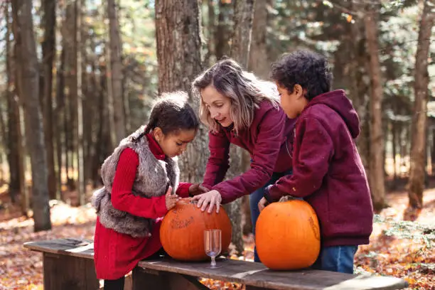 Mixed race family decoration pumpkins, during autumn, Quebec, Canada