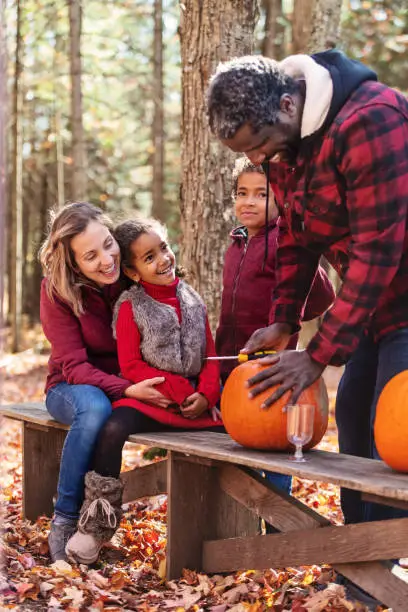 Mixed race family decoration pumpkins, during autumn, Quebec, Canada