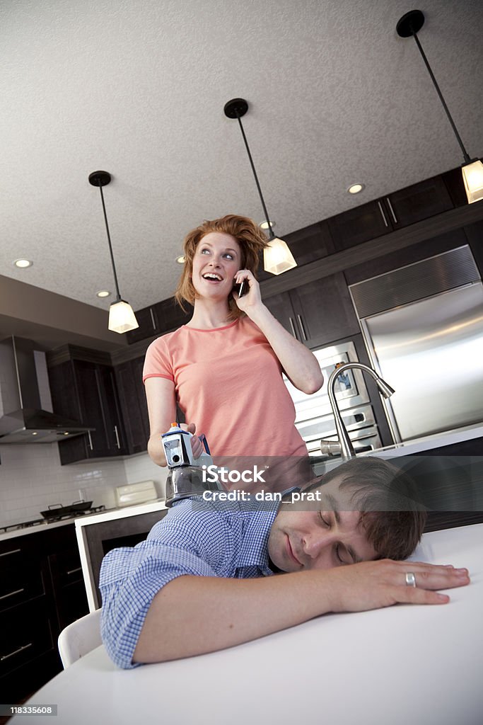 Distracted Wife Ironing A distracted wife ironing her dead husband while talking on the phone. Bizarre Stock Photo