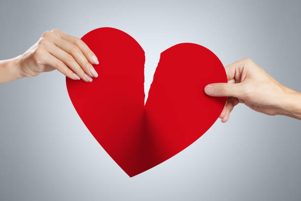 Hands tearing a red heart Male and female hands tearing a red heart symbol of love in half breaking photos stock pictures, royalty-free photos & images