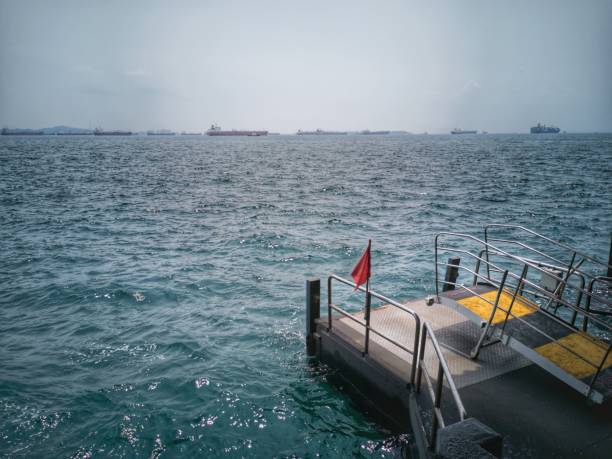 istock Jetty dock by the sea with red flag 1183360786
