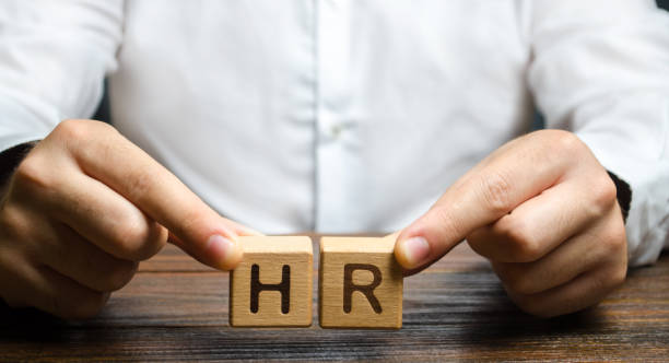 istock Businessman holds two blocks with HR. Recruiting new workers, headhunters Human resources. Search for talented worker. Assessment of qualities skills. Attraction of valuable personnel to the company 1183362642