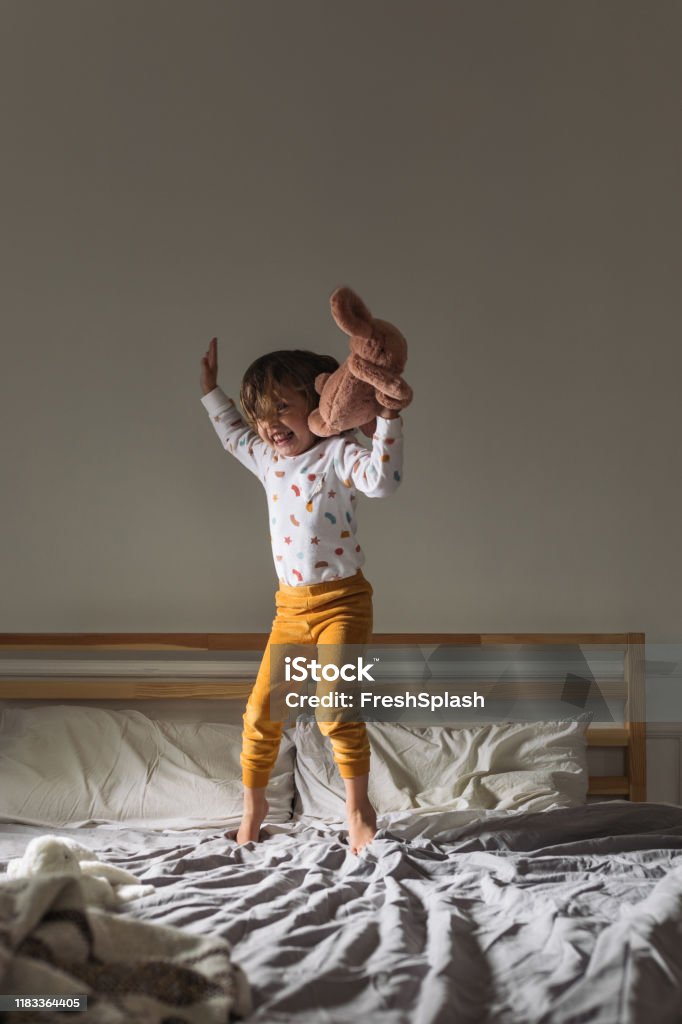 Kleines Mädchen springt auf ein Bett - Lizenzfrei Kind Stock-Foto