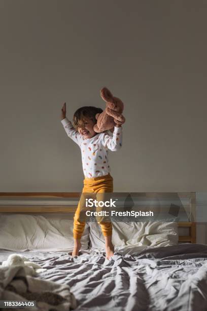 Kleines Mädchen Springt Auf Ein Bett Stockfoto und mehr Bilder von Kind - Kind, Aufwachen, Bett