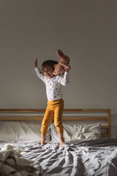 istock Little Girl Jumping on a Bed 1183364405