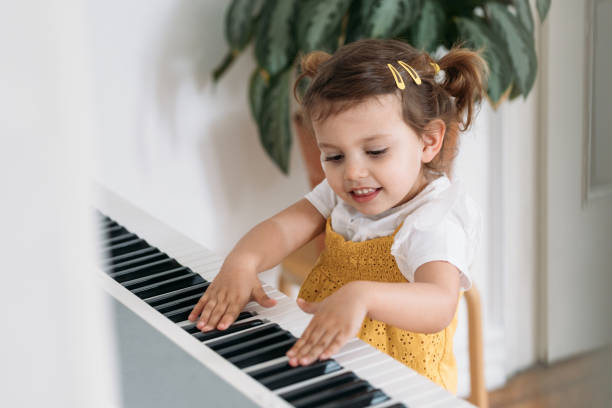 istock Cute Little Girl Playing Piano 1183364414