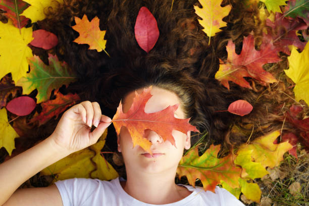 istock Woman lying among autumn leaves 1183365015