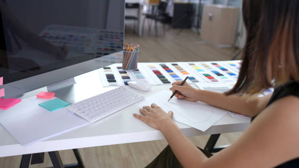 istock Creative designer drawing and sketching new ideas on paper in the office 1183366053