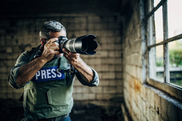 istock Mature guy war journalist taking pictures with camera 1183367460