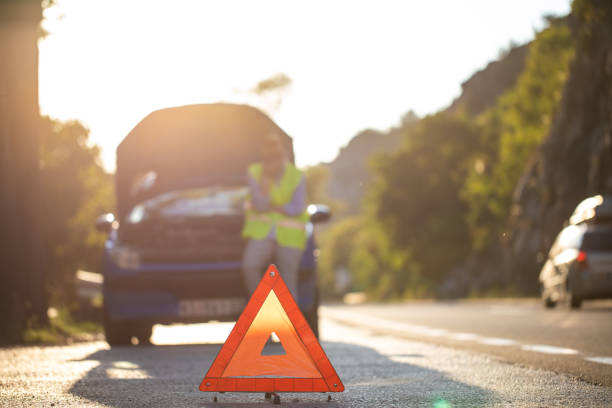 istock Warning triangle in front of the broken down vehicle on the highway 1183367736