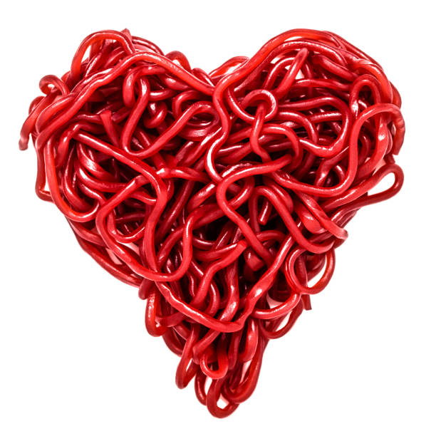 Red love heart shape made of sweet jelly laces isolated on white background. Valentine's Day. Cut out