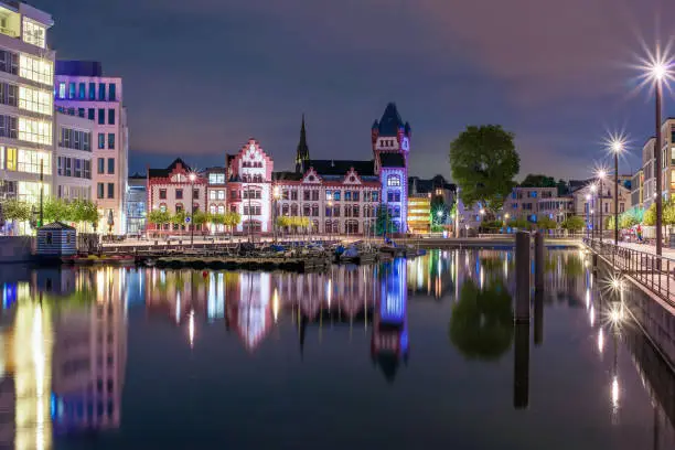 Amazing nightscape of Hoerde Castle and Phoenix Lake (Phoenixsee) in Dortmund, Germany illuminated at night. It is an artificial lake and recreational area on the former steelworks