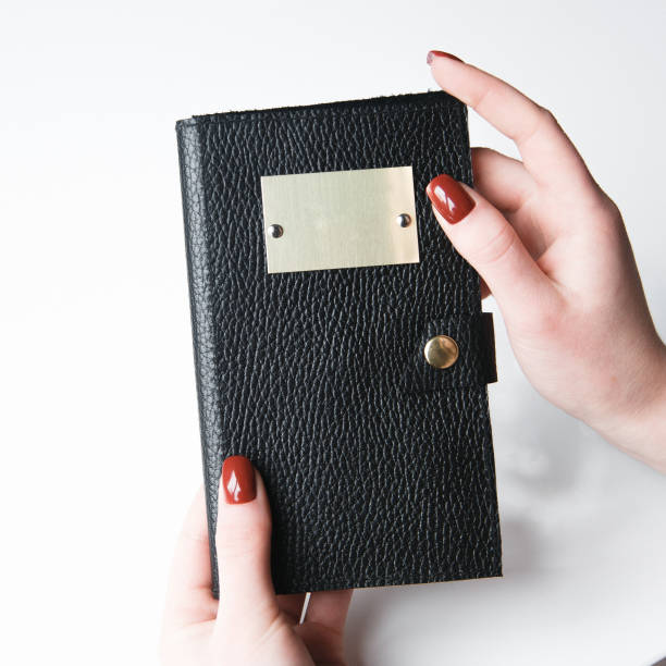 istock Black leather case on white background. Hands with the packaging for makeup brushes. 1183374608