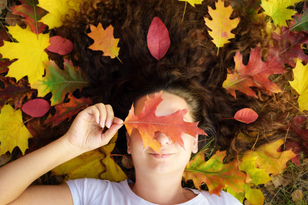 istock Woman lying among autumn leaves 1183374931
