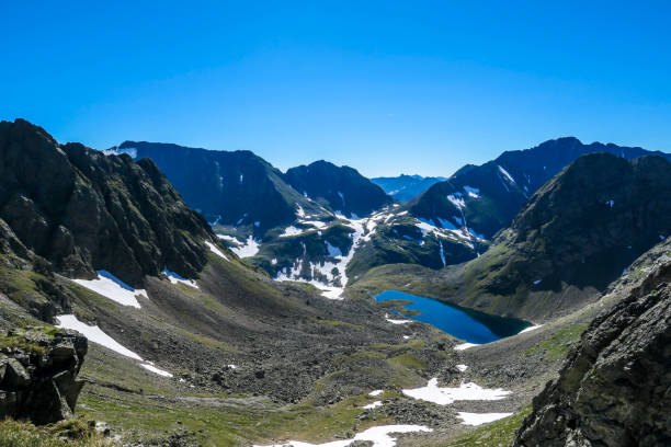 istock Schladming - A remote view on a lake hiding between tall Alps 1183375054
