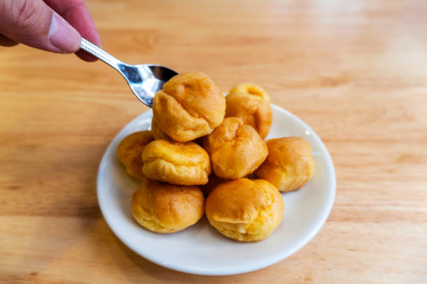 istock Cream puffs or eclair or choux cream with vanilla custard on wooden table on white plate put on wood table 1183376092