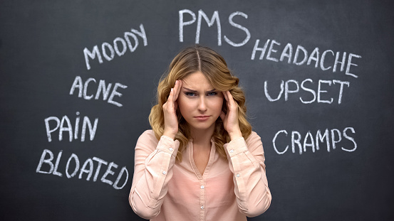 Mujer que sufre dolor de cabeza debido a problemas imaginarios en pms, desequilibrio hormonal photo