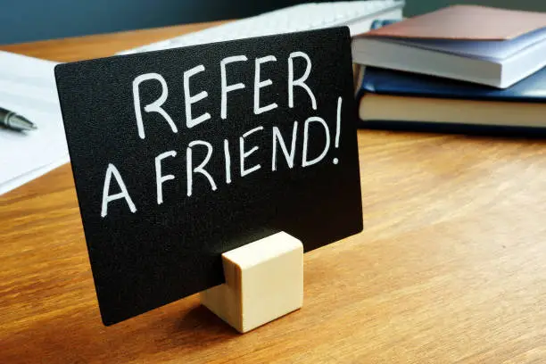 Photo of Refer a friend concept plate on the desk.