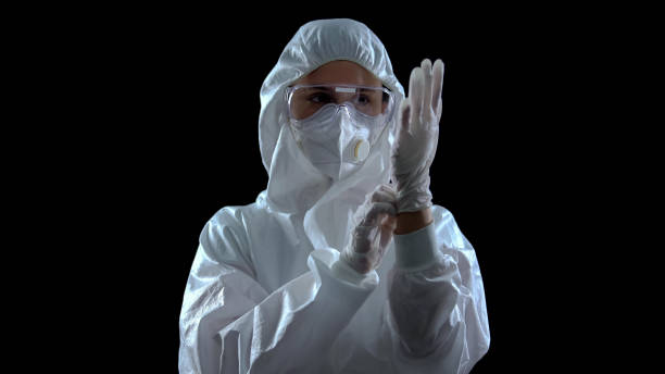 person in protective suit wearing rubber gloves against dark background, toxins - effort dark concepts women imagens e fotografias de stock