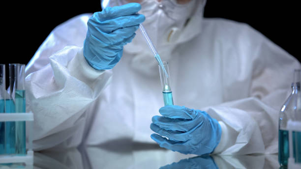 istock Chemistry lab assistant taking sample of blue liquid from test tube, experiment 1183377060