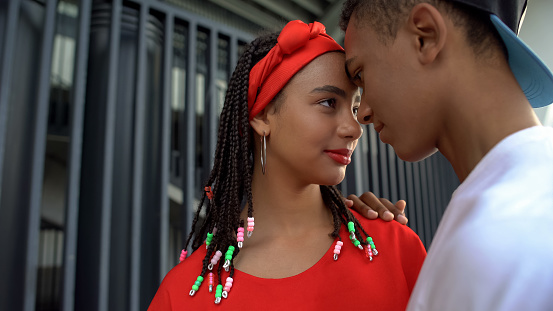 Boyfriend tenderly hugging his girlfriend, moment of first kiss, affection