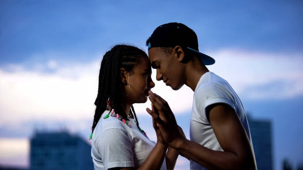 Teenage couple putting foreheads together, holding hands, full trust concept Teenage couple putting foreheads together, holding hands, full trust concept teen romance stock pictures, royalty-free photos & images