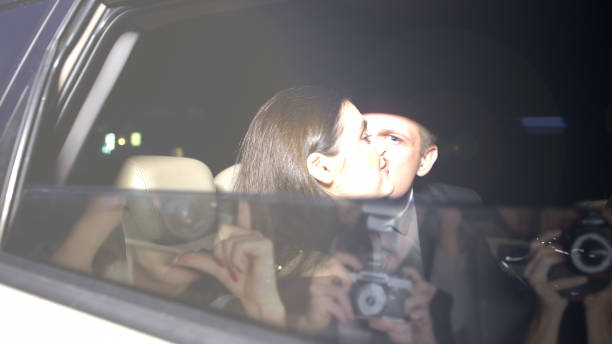 celebrities kissing on backseat of car paparazzi cameras shooting lovers, secret - relationship difficulties flash imagens e fotografias de stock