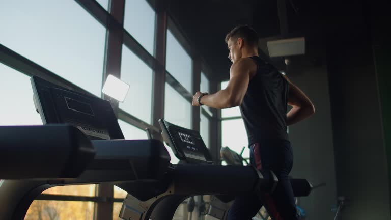 Young athletic men and women exercising and walk on treadmill in sport gym