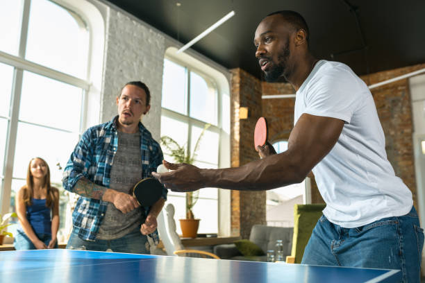istock Young people playing table tennis in workplace, having fun 1183383653