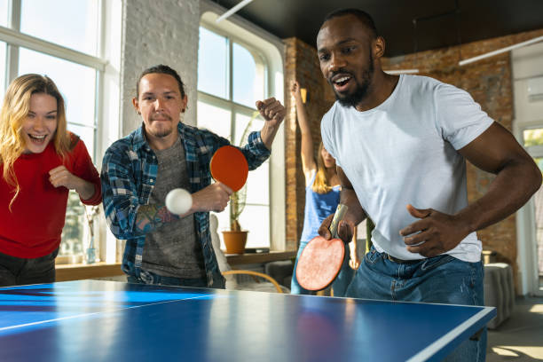 istock Young people playing table tennis in workplace, having fun 1183383669
