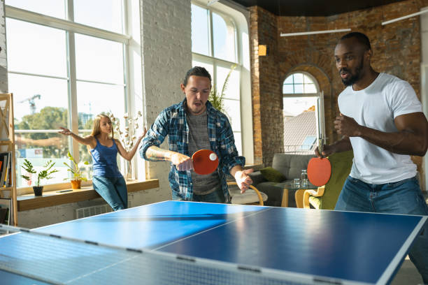 istock Young people playing table tennis in workplace, having fun 1183383675