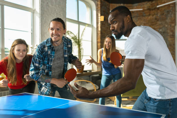 istock Young people playing table tennis in workplace, having fun 1183383680